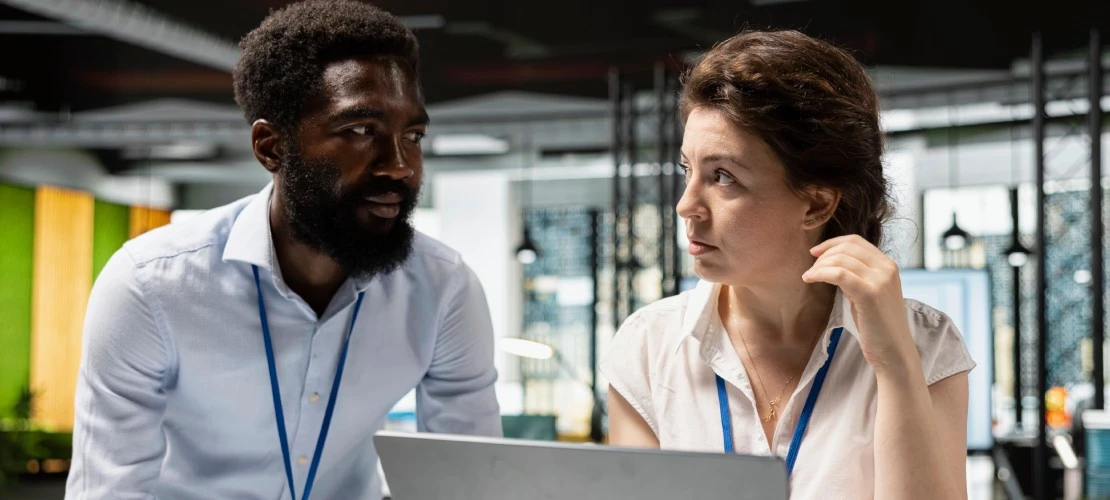 Two business professionals reviewing a technology implementation plan and adoption strategy