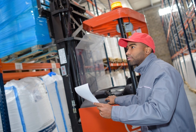 forklift operator reviewing warehouse flow and process documentation during a warehouse optimization project