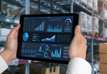 consultant reviewing inventory policy and ERP replenishment data on a tablet in a warehouse setting