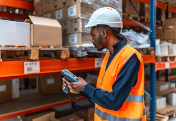 warehouse worker in safety vest scanning inventory as part of a slotting and cycle count optimization process