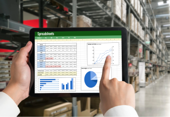 consultant reviewing warehouse ERP and WMS data alignment on a tablet in a distribution facility