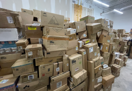disorganized warehouse with stacked boxes illustrating the operational pain points that warehouse optimization consulting is designed to solve